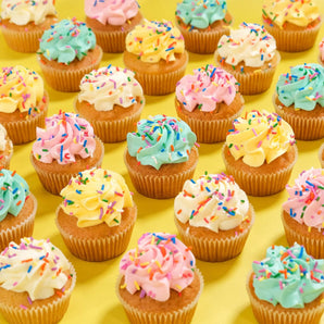Vanilla Cupcakes from Crumbs & Doilies with colourful icing and sprinkles, freshly baked and perfect for any occasion.